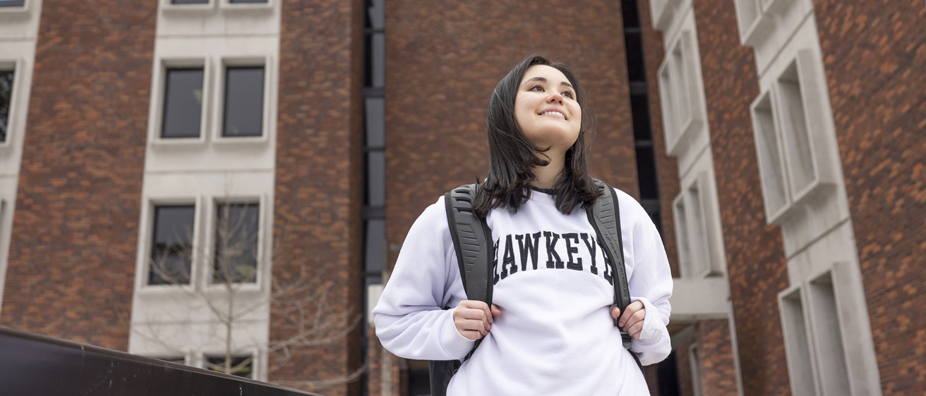 Student wearing Hawkeye sweatshirt walking out of EPB