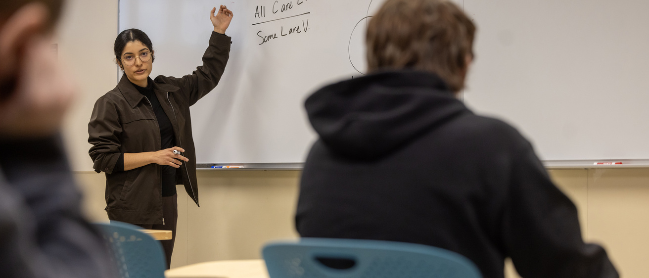 professor at whiteboard teaching a philosphy class